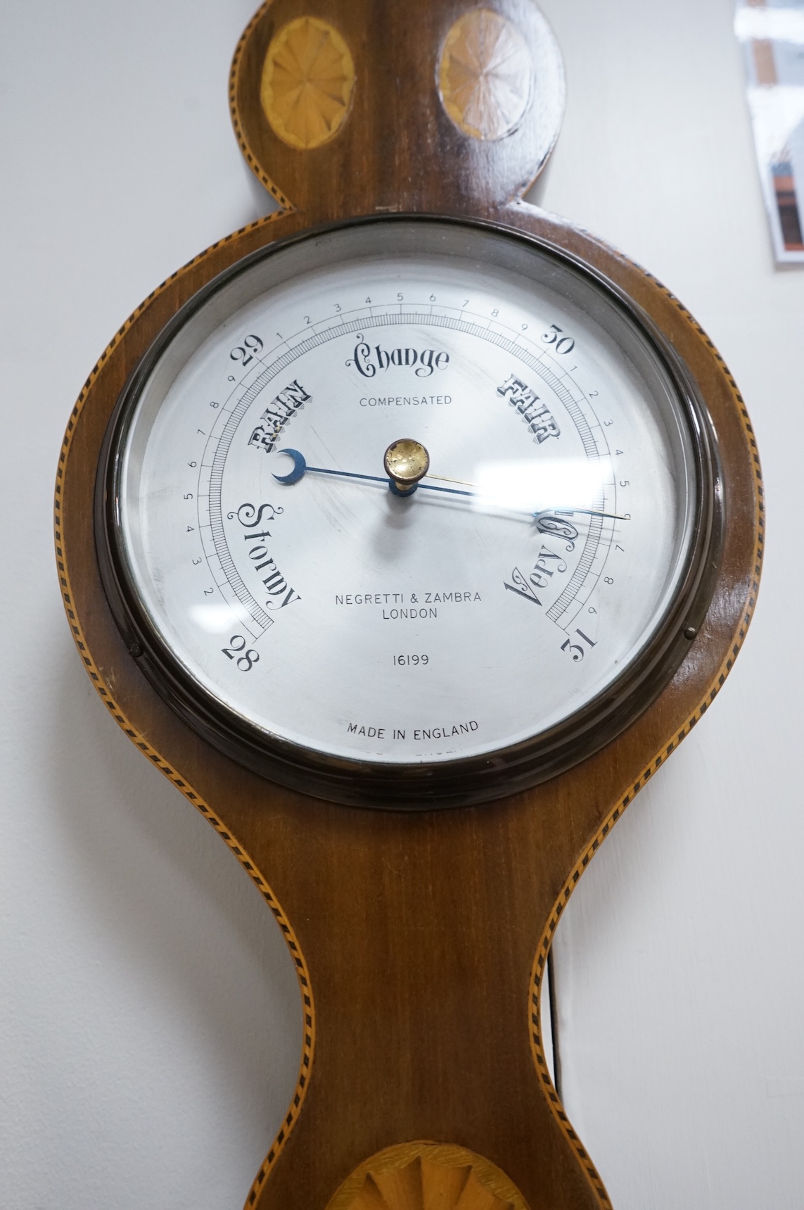 An Edwardian style inlaid mahogany Negretti & Zambra wheel barometer / thermometer, 82cm high